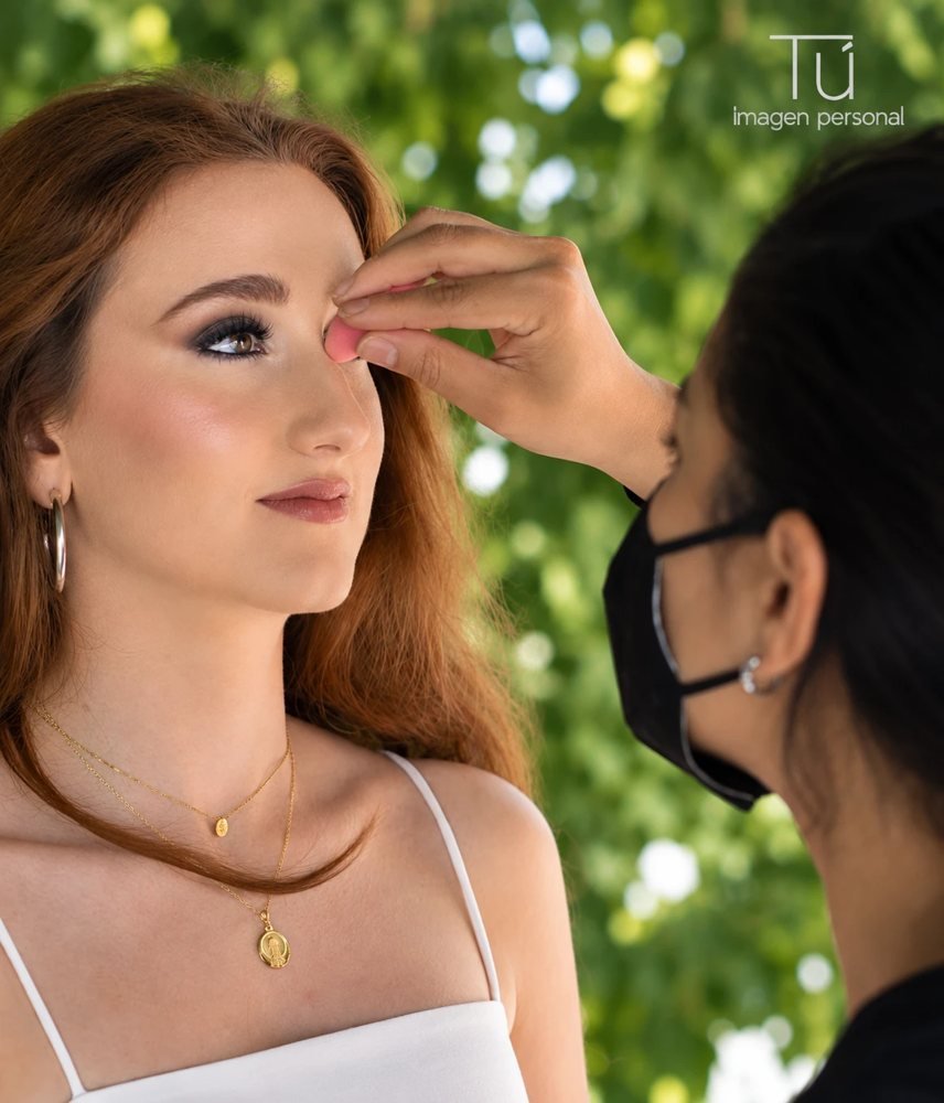 Maquilladora profesional aplicando maquillaje a una modelo al aire libre